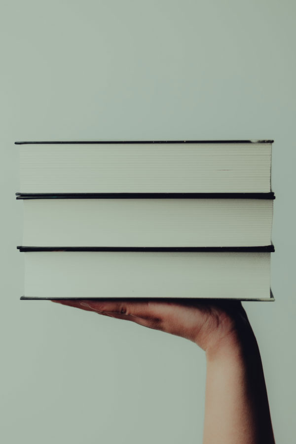Mano sosteniendo una selección de libros
